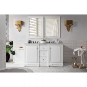A modern bathroom showcases the De Soto 60 inch Double Bathroom Vanity in Bright White with two mirrors. Gold sconces on the walls and soft candlelight enhance the ambiance, while green plants contrast with the white and gray decor. Towels are neatly placed on both the countertop and tub edge.