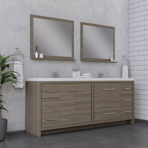 Experience the sleek design of the Sortino 84 Inch Double Bathroom Vanity With Sink - Gray, featuring a wooden finish, chrome fixtures, two large mirrors, tiled walls, and a potted plant for decor. Ideal for storage with its ample drawer space.