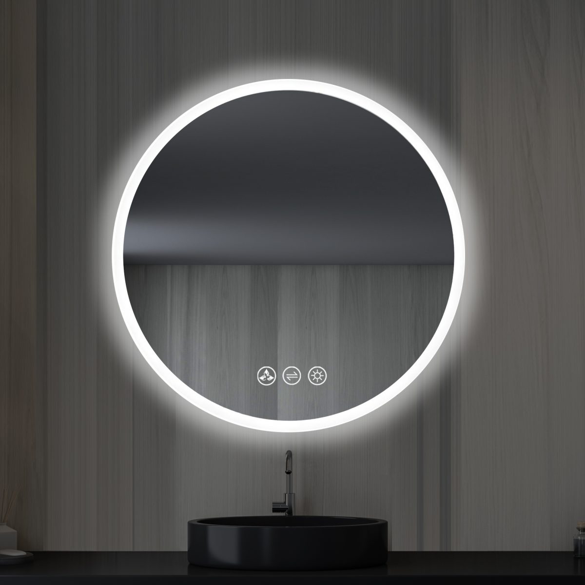 A modern bathroom features the Orion 24 inch Round LED Mirror with Frosted Side, beautifully backlit on a wooden wall. Below, a sleek black sink with a minimalist faucet complements the touch-sensitive icons for lighting and other functions on the mirror.