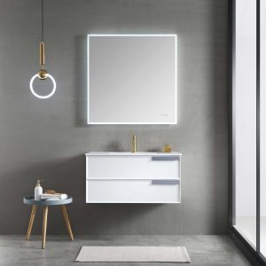 Sleek bathroom with the Sofia 36 Wall Mount Vanity in Matte White, featuring a white sink and two drawers. A square backlit mirror hangs above, while a round side table holds toiletries. A pendant light and window illuminate the space, complemented by a rectangular rug.