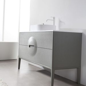 The Colmar 48-inch olive green freestanding vanity features two drawers with a circular indentation on the upper drawer, a white countertop, and a white vessel sink with a minimalist faucet for a modern look.