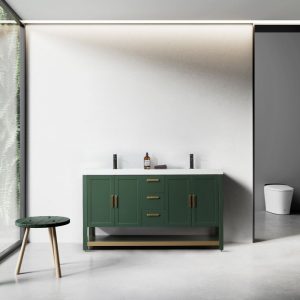 A modern bathroom features a Winchester 60 Forest Green Freestanding Vanity with a white countertop and gold handles. Dual faucets stand next to a bottle, with a round green stool on wooden legs nearby. The minimalist design includes a wall-mounted toilet in the background.
