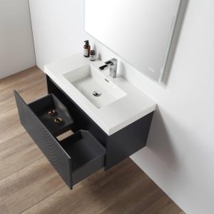 The Positano 36 inch Wall Mount Bathroom Vanity in Night Blue features a white sink, wall-mounted faucet, large mirror, and two open black drawers with gold accents, set against a white wall and wood floor.