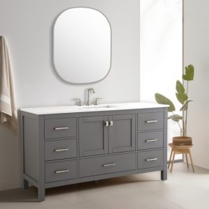 In a modern bathroom, the Vanea 60 Single Bathroom Vanity boasts a gray finish, six drawers, and two central doors. It features a white quartz top with a stainless steel faucet. A rounded rectangular mirror hangs above, with decor completed by towel on a rack.