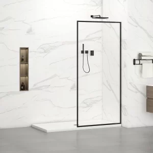 A minimalist bathroom features a shower with a marble pattern and sleek black Neil 34W x 76H Walk In Shower Screen Door. Modern fixtures accent the space, with shelves to the left for bottles and gray floor tiles enhancing the partial view of a wooden vanity.