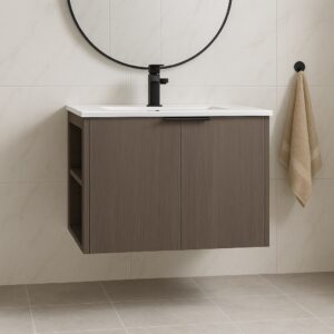 The modern bathroom features an Elmridge 30 wall-mounted vanity with sink in a floating wooden design, a round mirror above, a beige towel on a black hook, and is enhanced by light-tiled walls and flooring.