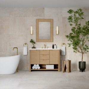 Modern bathroom with a freestanding white bathtub, Solene 48 inch Single Bathroom Vanity Cabinet with mirror, gold fixtures, neatly folded towels, and a potted tree on tiled floor and wall. The minimalistic space is bright and well-lit.