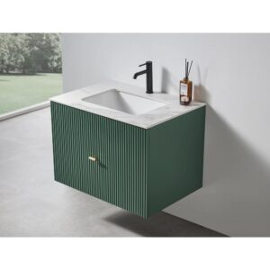 The Barcelona 30 Inch Wall Mount Bathroom Vanity showcases vertical grooves, a white integrated sink countertop, black faucet, toiletries, and a modern green finish with a gold handle—contrasting beautifully with a white wall and grey floor.