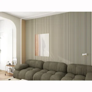 A modern living room features a green tufted sofa, an Acoustic Interior Wall Panel in beige with abstract art, a small side table displaying decor items, and is bathed in soft, natural light.