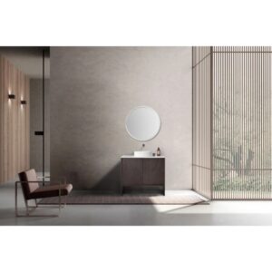 Minimalist bathroom featuring the Celle 36 Inch Bathroom Vanity With Vessel Sink topped with a round mirror, a modern chair on the left, and a large window with vertical wooden slats letting in natural light.