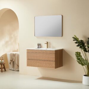 A modern bathroom with a Linea 36 Inch Wall Mounted Bathroom Vanity, rectangular mirror, two small bottles on the sink, a potted plant, and neutral beige walls. A towel and tray sit on a bench visible through an arched doorway.